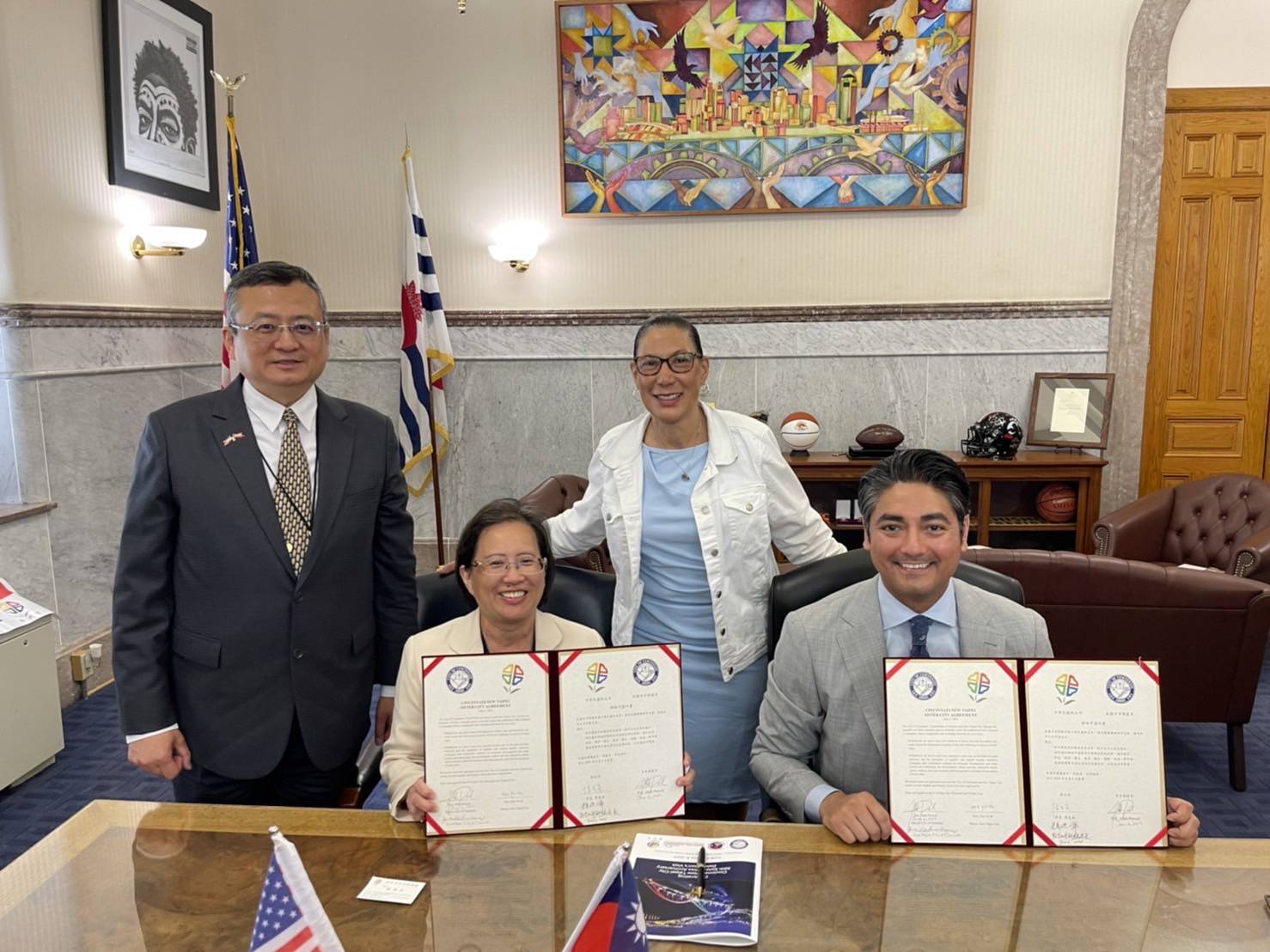  Cincinnati Mayor Aftab Pureval (right) and Dr. Caroline Lu-Lin Wang, Inspector of the New Taipei City Education Department (second from left), hold the sister city agreement. In the background, from left: Director General Yen-Feng Lei of the Taipei Economic and Cultural Office in Chicago, and Vice Mayor of Cincinnati, Jan-Michele Kearney.