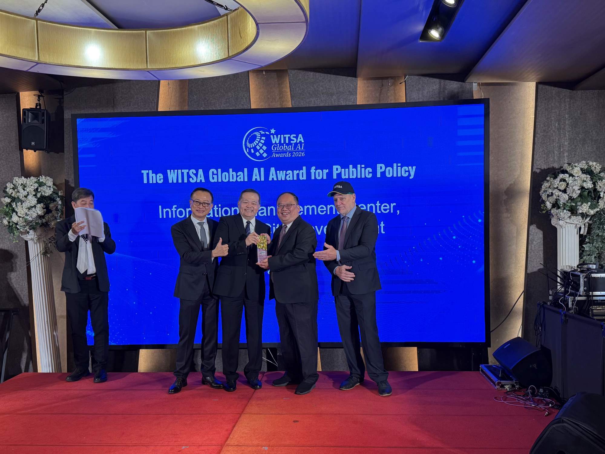 Chen Fu-Tien (second right), Director of the Information Center, represents New Taipei City at the 2026 WITSA Global AI Award ceremony to receive the award.