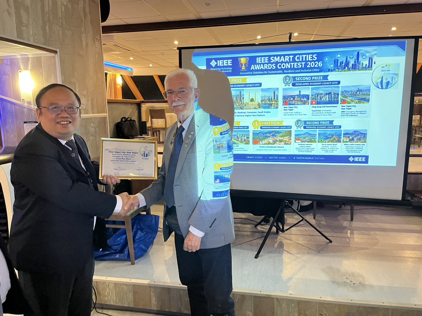 New Taipei City Government attends the 2026 IEEE International Smart Cities Contest and Awards Ceremony. IEEE Smart Cities Contest Chair Gustavo Giannattasio (right) presents the award to Chen Fu-Tien (left), Director of the Information Management Center, who represented the New Taipei City Government in receiving the award.